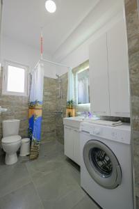a bathroom with a washing machine and a toilet at Villa e Olsi Kacupaj in Sarandë