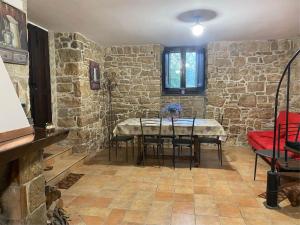 a dining room with a table and a stone wall at IL CAMINETTO in Carpinone