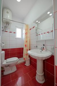 a bathroom with a white sink and a toilet at Villa e Olsi Kacupaj in Sarandë +8 photos