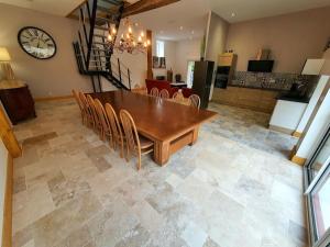 a dining room with a wooden table and chairs at Gite de la grange 14 couchages in Saint-Amand-Montrond