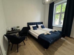 1 dormitorio con cama, escritorio y ventana en IRIS Aparthotel, en Cracovia