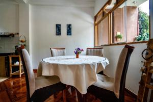 uma sala de jantar com uma mesa e cadeiras com um vaso sobre ela em Blue Lotus Retreat Center em Písac