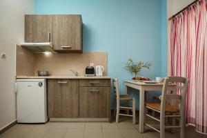 a kitchen with a white refrigerator and a table at Kalami apartment in Falasarna in Falasarna