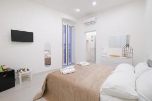 a white bedroom with a large bed with white pillows at Antonia’s House in Bari