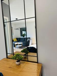 um espelho sobre uma mesa em frente a uma sala de estar em Apartamenty Dębowa 1 PRIV OGRÓD Z MIEJSCEM NA ROWERY em Milicz