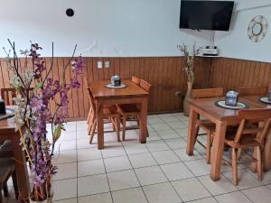 a dining room with tables and chairs and a tv at Hotel Mar Sur in Talcahuano