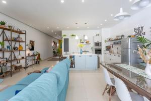 a living room with a blue couch and a kitchen at Namaste :) Enjoy Every Moment in Mellieħa