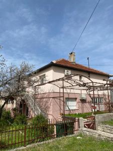 a pink house with a fence in front of it at Apartman Nađa in Bileća