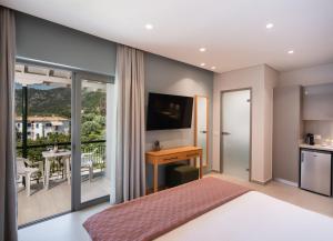 una camera con letto e una cucina con balcone di Niriton Residence Brand new Nydri Suites a Nydri
