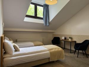 1 dormitorio con 2 camas, ventana y escritorio en IRIS Aparthotel en Cracovia
