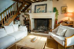 sala de estar con sofá blanco y chimenea en Home - Chastenay - Séjour à Ouanne, en Ouanne