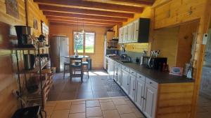 a large kitchen with white cabinets and a table at Grand Chalet in Bourbon-Lancy