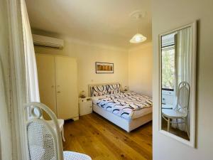 1 dormitorio con 1 cama, 1 silla y 1 ventana en Villa Verde Piran, Authentic Mediterranean Stay en Piran