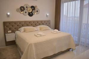 a bedroom with a large bed with a clock on the wall at Villa Lauvi, Free Fiat 500 Cabriolet, Scooters , PS5 in Kaštela +81 photos