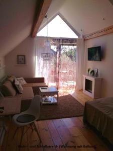 ein Wohnzimmer mit einem Bett, einem Sofa und einem Fenster in der Unterkunft Ferienwohnungen zentral Altötting in Altötting