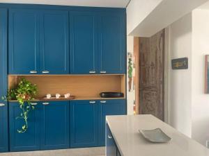 a kitchen with blue cabinets and a table at Apto 3q Urca vista Baía e Cristo in Rio de Janeiro