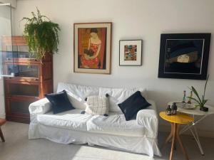 uma sala de estar com um sofá branco e uma mesa em Apto 3q Urca vista Baía e Cristo no Rio de Janeiro