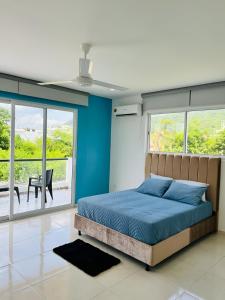 1 dormitorio con 1 cama con paredes y ventanas azules en AzulRest Casa de Verano en Juan de Acosta