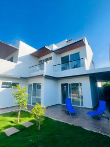 a house with two blue chairs in front of it at AzulRest Casa de Verano in Santa Verónica