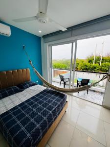 AzulRest Casa de Verano في Juan de Acosta: غرفة نوم مع سرير وأرجوحة وشرفة
