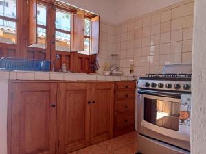 a kitchen with wooden cabinets and a stove at Casa Brisa in Tapalpa