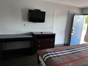 a hotel room with a bed and a desk and a television at Scottish Inn Augusta downtown in Augusta