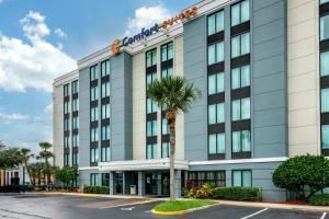 an office building with a palm tree in front of it at Comfort Suites Baymeadows Near Butler Blvd in Jacksonville