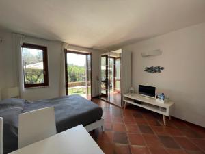 1 dormitorio con 1 cama y mesa con TV en Residence Albatros-Golf & Relax, en Toscolano Maderno