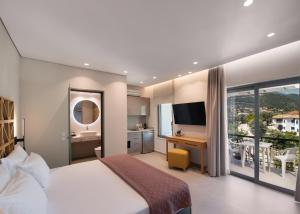 a bedroom with a bed and a desk with a television at Niriton Residence Brand new Nydri Suites in Nydri
