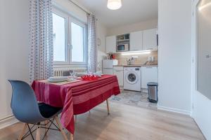 a kitchen with a table with a red table cloth on it at Le Clemenceau in Thionville +5 photos
