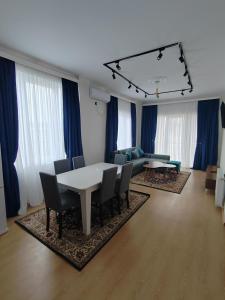 een woonkamer met een tafel en stoelen en blauwe gordijnen bij Vacation villa in Soghanlughi