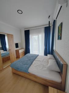een slaapkamer met een bed en een raam met blauwe gordijnen bij Vacation villa in Soghanlughi