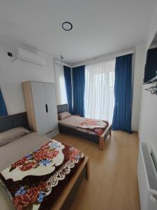 twee bedden in een kamer met blauwe gordijnen bij Vacation villa in Soghanlughi