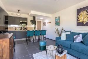 a living room with a blue couch and a kitchen at Le cosy de Duingt charmant appartement à 150m du lac in Duingt