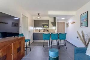 a kitchen and living room with blue bar stools at Le cosy de Duingt charmant appartement à 150m du lac in Duingt