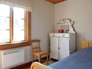 um quarto com uma cama, uma cadeira e uma janela em Holiday home NORDINGRÅ em Nordingrå