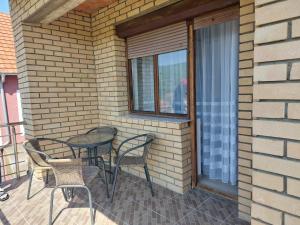 a patio with chairs and a table and a window at Apartmanii Gajić in Kuršumlija