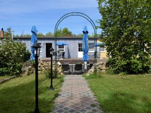 a walkway with blue umbrellas in a yard at Pretty Apartment in Wiek with Garden in Wiek auf Rügen 