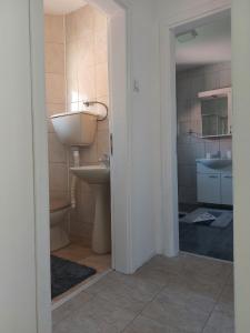 a bathroom with a sink and a toilet and a mirror at Apartmanii Gajić in Kuršumlija
