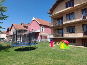 a yard with a playground in front of a building at Apartmanii Gajić in Kuršumlija