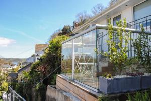 a glass house on the side of a house at 2 Rockmount in Salcombe