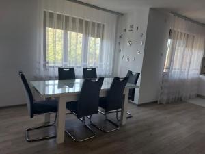 a dining room with a glass table and chairs at Apartmanii Gajić in Kuršumlija