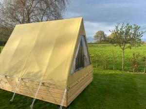 a yellow tent sitting on the grass in a field at The Garden Tent in Whitchurch