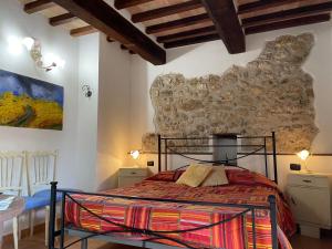 a bedroom with a bed and a stone wall at La Casa di Gelsomino in Massa Martana