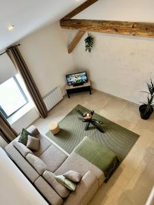 einen Blick über ein Wohnzimmer mit Sofa in der Unterkunft La Maison du Cocher in Étival-Clairefontaine