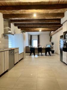 eine Küche mit Holzdecken und ein Esszimmer in der Unterkunft La Maison du Cocher in Étival-Clairefontaine
