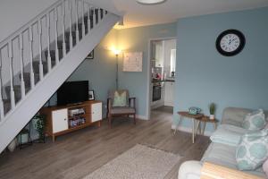 sala de estar con escalera, sofá y TV en Snowdon Snug en Llanberis