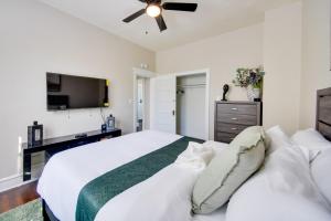 a bedroom with a white bed and a flat screen tv at Waterfront Portsmouth Apt half Mi to Dtwn and Ferry in Portsmouth