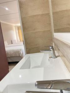 a bathroom with a sink and a mirror and a bed at Henwood House in Durban