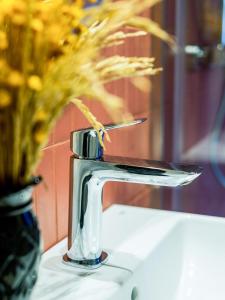 a chrome bathroom faucet with a vase of flowers at Hostal Barris in Pals